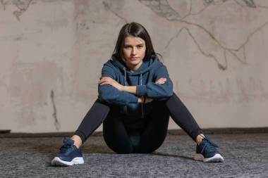 女孩坐在健身房的地板上