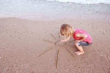 女孩繪制太陽(yáng)在沙子上海灘圖片