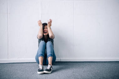 沮喪的黑發(fā)女人，雙手坐在頭上，在家里尖叫