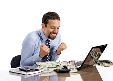 年轻的现代商人兴奋与他的成功与他的笔记本电脑和会计收入工作时