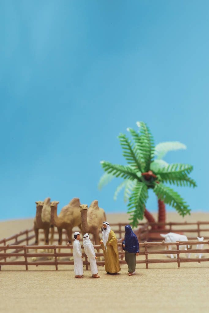 微型玩具阿拉伯男人和妻子在阿巴亚购买骆驼和绵羊 微型玩具阿拉伯男人和妻子在阿巴亚购买骆驼和绵羊