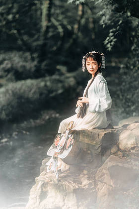 亚洲妇女在传统的礼服在大自然中摆姿势