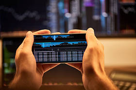 裁剪视图的人拿着智能手机与图形和图表 