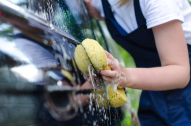 女手以黃色海綿洗車