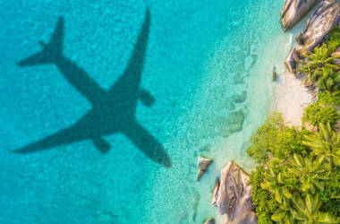 帶飛機(jī)陰影和海灘的旅行理念圖片