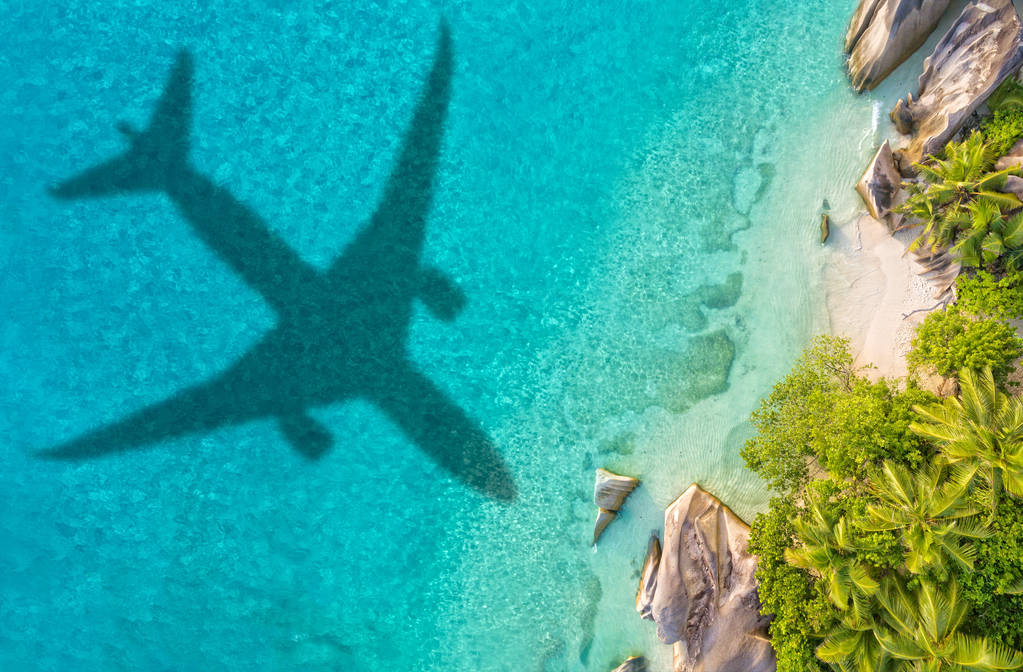带飞机阴影和海滩的旅行理念图片
