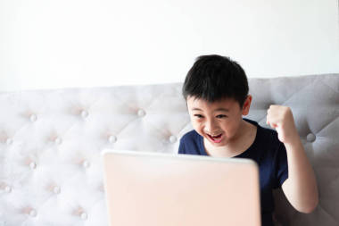 小男孩使用筆記本電腦玩游戲在家里放松