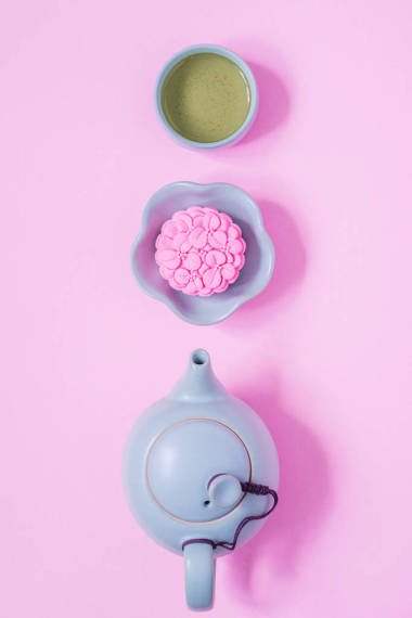 粉紅月餅，藍色茶壺，粉紅色背景上的綠茶。中國中秋節(jié)食
