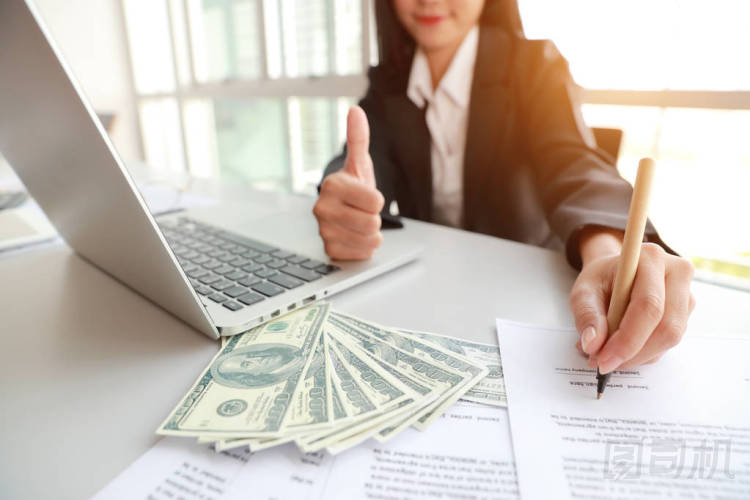 女商人簽署合同,并表現(xiàn)出大拇指與錢 