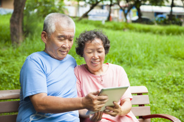 快樂老人夫婦與 tablet pc 在公園