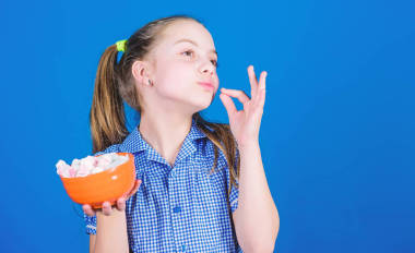 饑餓的女孩。飲食和卡路里。甜食概念?？鞓佛囸I的小孩喜歡甜食和食物。棉花。糖果店健康食品和牙科護理。小女孩吃棉花糖