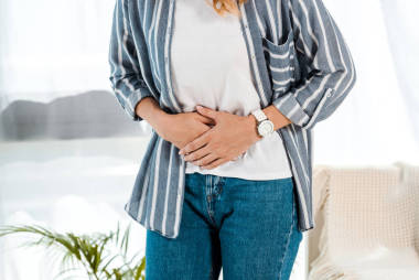 婦女有胃痛在家里的裁剪視圖 