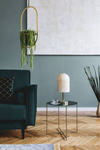 時尚豪華的客廳室內(nèi)設(shè)計，配有綠色天鵝絨沙發(fā)、設(shè)計咖啡桌、大理石臺燈、掛金花壇和典雅的配飾。模板?，F(xiàn)代家居裝飾. 