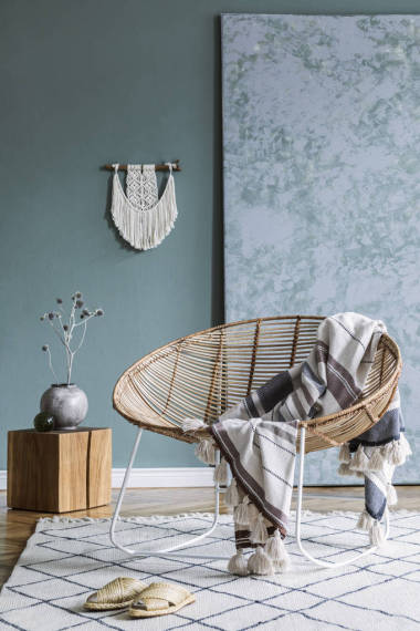 时尚的简约客厅内部，配有设计藤式扶手椅和优雅的配饰。墙的紫杉颜色。复制空间