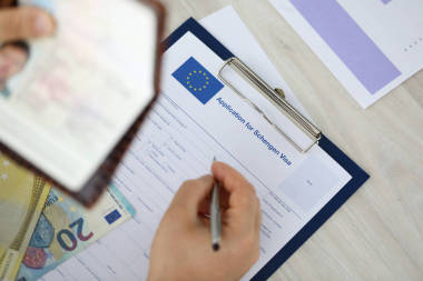 男性手拿着银笔与护照图片