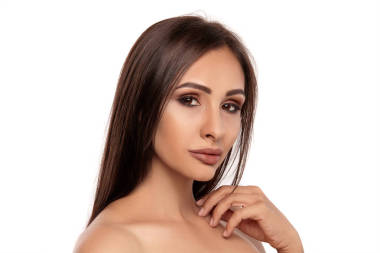 一個(gè)有著專業(yè)晚妝和豐滿嘴唇的黑發(fā)模特的近照，在白色背景下顯得孤立無援