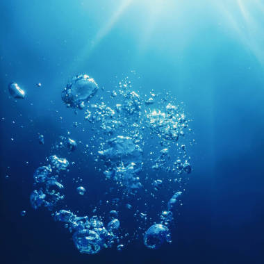 与阳光的水下气泡。水下背景气泡