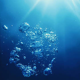 与阳光的水下气泡。水下背景气泡