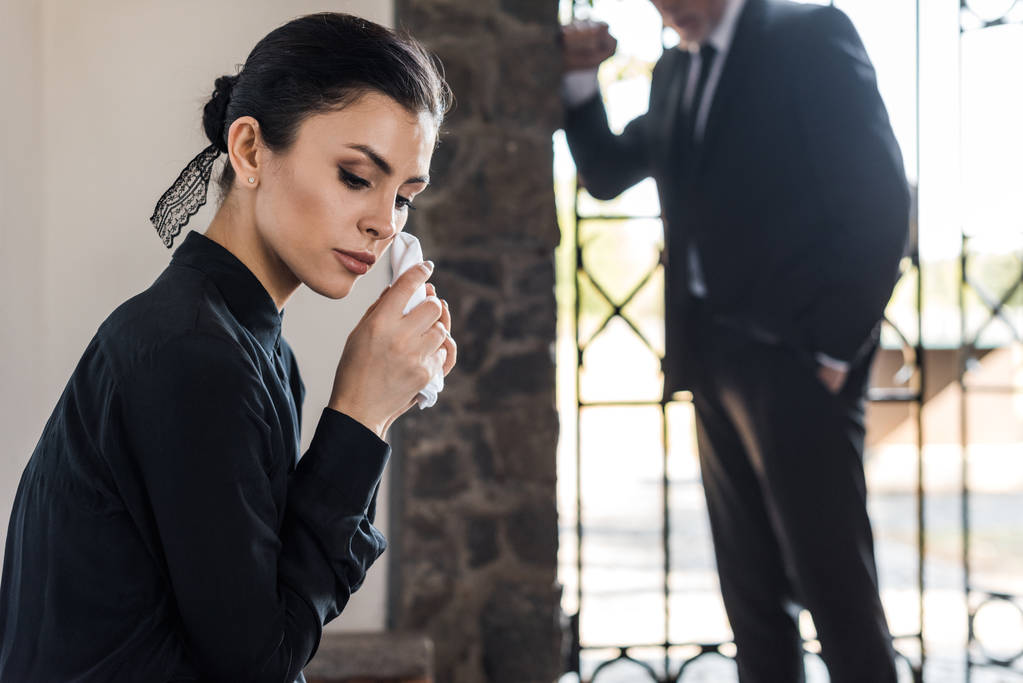 选择性的焦点不安的女人拿着手帕，而哭接近高级男子