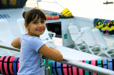 女孩在碼頭上，在船和海的背景