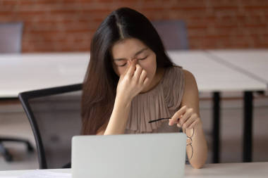 疲惫的亚洲商业女性患有眼睛疲劳