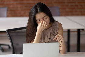 疲惫的亚洲商业女性患有眼睛疲劳