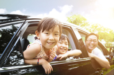 快樂的小女孩與家人圍坐在車