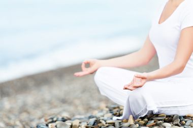 海滩上的瑜伽姿势打坐的女人的手
