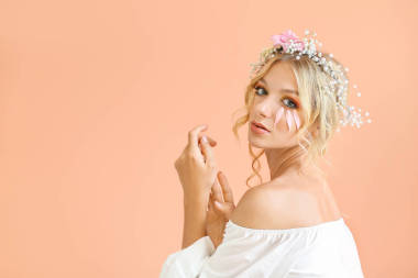 美丽的少妇与花花圈在颜色背景