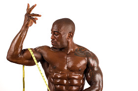 考虑他肌肉测量与一厘米的黑色健美运动员。完美的肌肉强壮的男人。在白色背景上孤立