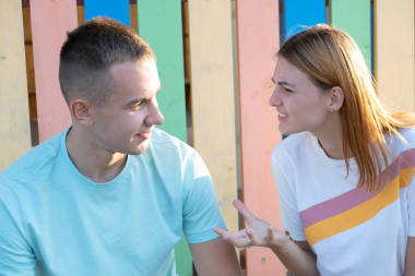 年輕夫婦在戶外爭吵。紅發(fā)女孩對(duì)她的男孩很生氣