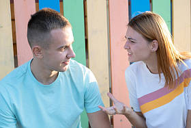 年轻夫妇在户外争吵。红发女孩对她的男孩很生气