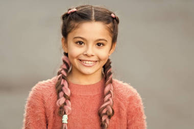 女孩與可愛的臉微笑在戶外。美麗的發(fā)型。時(shí)尚的發(fā)型為孩子們。小女孩與時(shí)尚辮子發(fā)型。時(shí)尚潮流。沙龍和護(hù)發(fā)。辮子發(fā)型