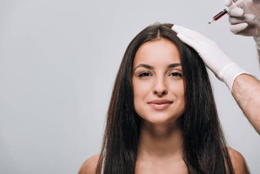 理覺師在乳膠手套做頭皮中療微笑美麗的女人與長發(fā)隔離在灰色