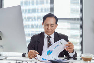 專注的亞洲商人在辦公室處理文件