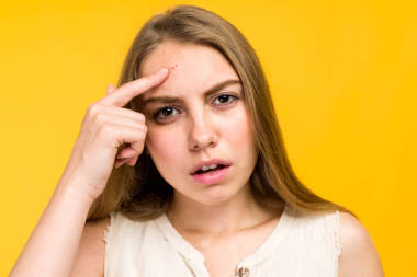 悲慘的青少年格爾觸摸她的臉和尋找痤瘡的肖像