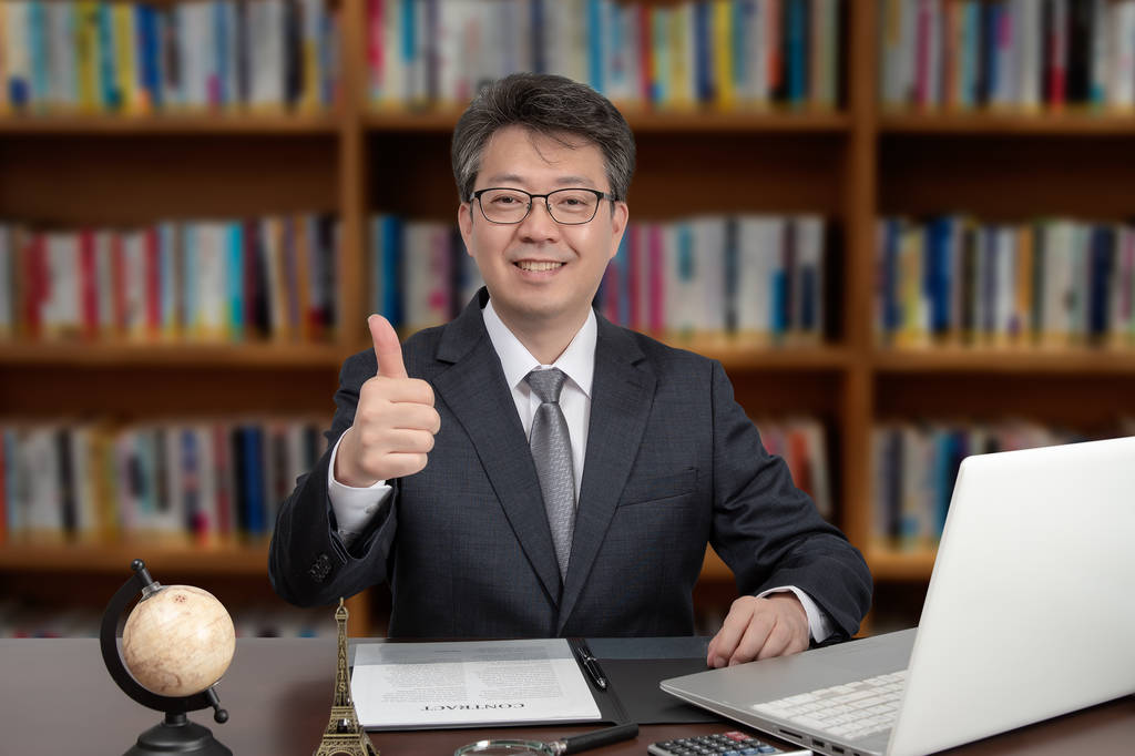 一张坐在办公桌前的亚洲中年男商人的画像
