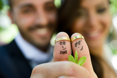 在他們的手指上的結婚戒指繪與新娘和新郎