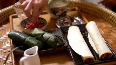 饮食饮食概念，素食主义。米饭与蘑菇和花生在香蕉叶，卷奶酪和果仁浆果在桌子上。中国菜