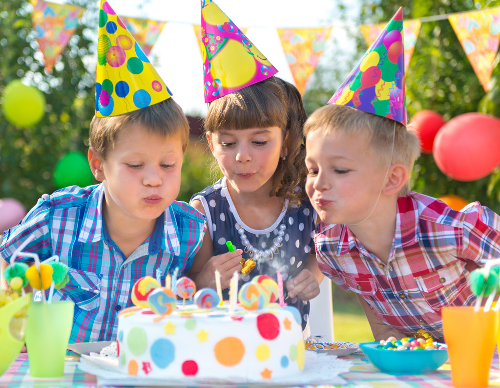 孩子们在生日蛋糕上吹蜡烛图片