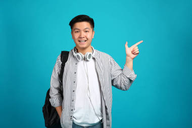 亞洲學生的肖像指在彩色背景上的東西