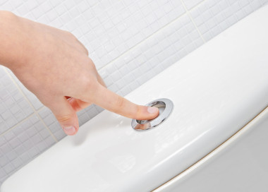 手指推按鈕和沖水馬桶圖片