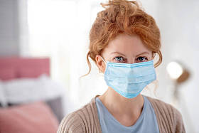 感染流感时戴口罩的年轻蓝眼睛女子