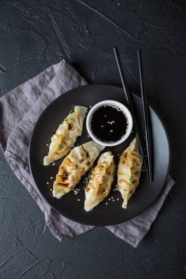 深色的桌子上放著填滿(mǎn)醬油的餛飩