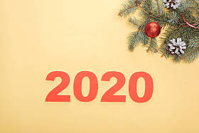俯视图纸2020数字附近的圣诞树树枝与小玩意和锥在黄色背景
