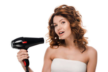 快樂的卷曲女孩，手里拿著被白色隔離的吹風(fēng)機(jī) 