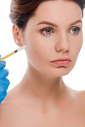 用胶乳手套夹着注射器的整形外科医生的剪影