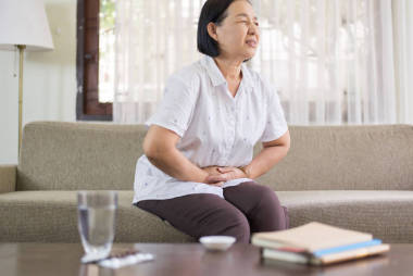 年長亞洲婦女在家中疼痛，老年女性患腹痛