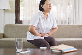 年长亚洲妇女在家中疼痛，老年女性患腹痛