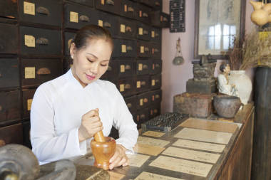 高級(jí)越南婦女在研磨砂漿配料時(shí)使用石灰和砂漿